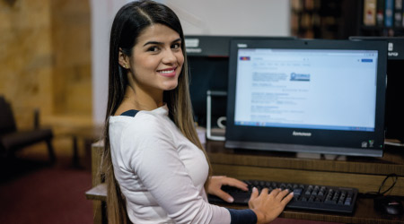Persona sentada frente a computador buscando programas virtuales