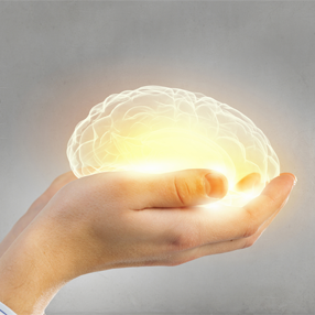 Foto de manos sosteniendo un cerebro luminoso