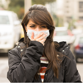 Foto persona con tapabocas previniendo la contaminación de la ciudad