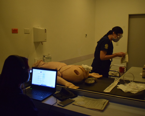 Fotografía de estudiante en un consultorio del CEC realizando un procedimiento de práctica